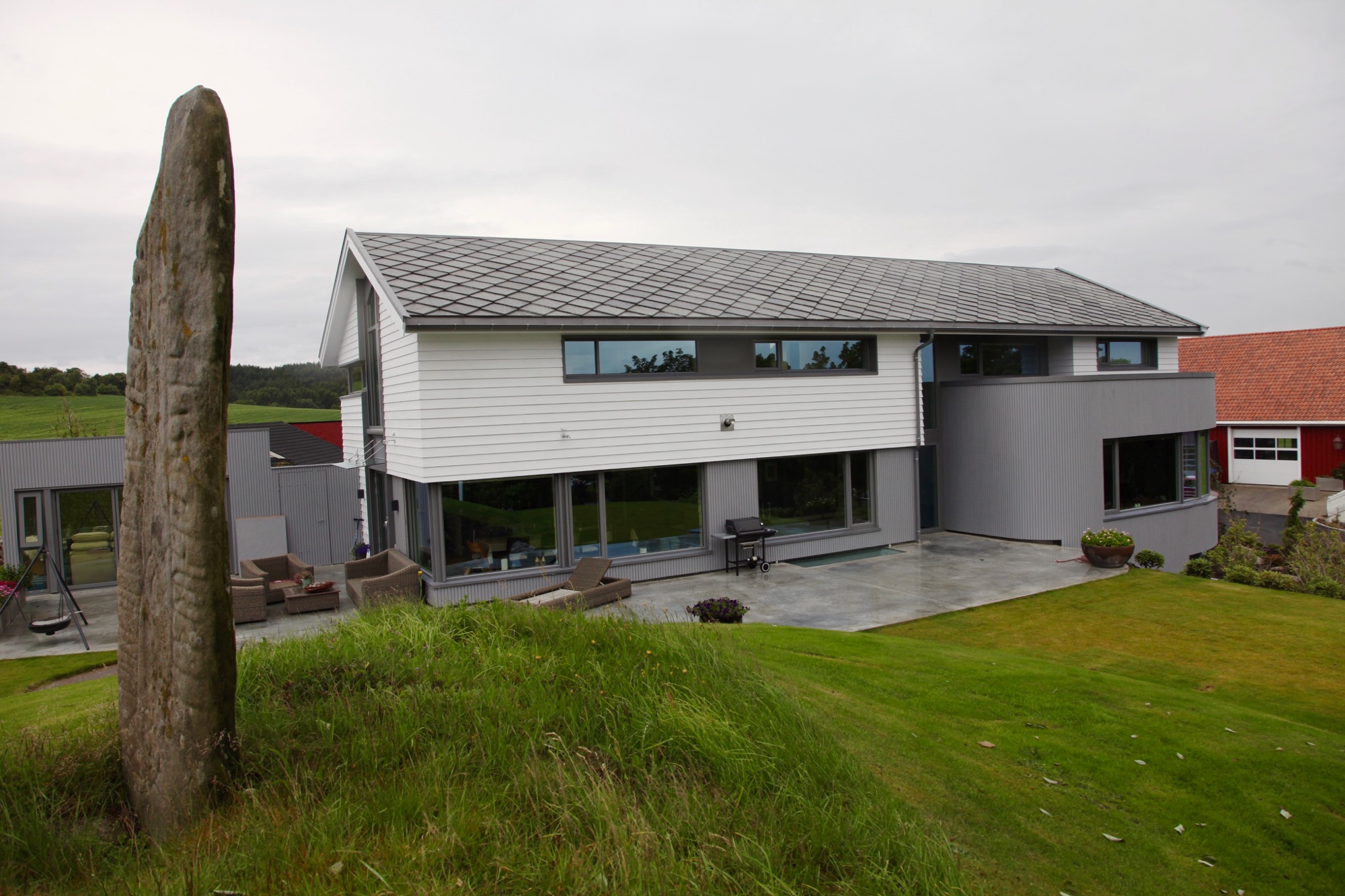 Hage og uteplasser på sørsiden med fornminne i forgrunnen