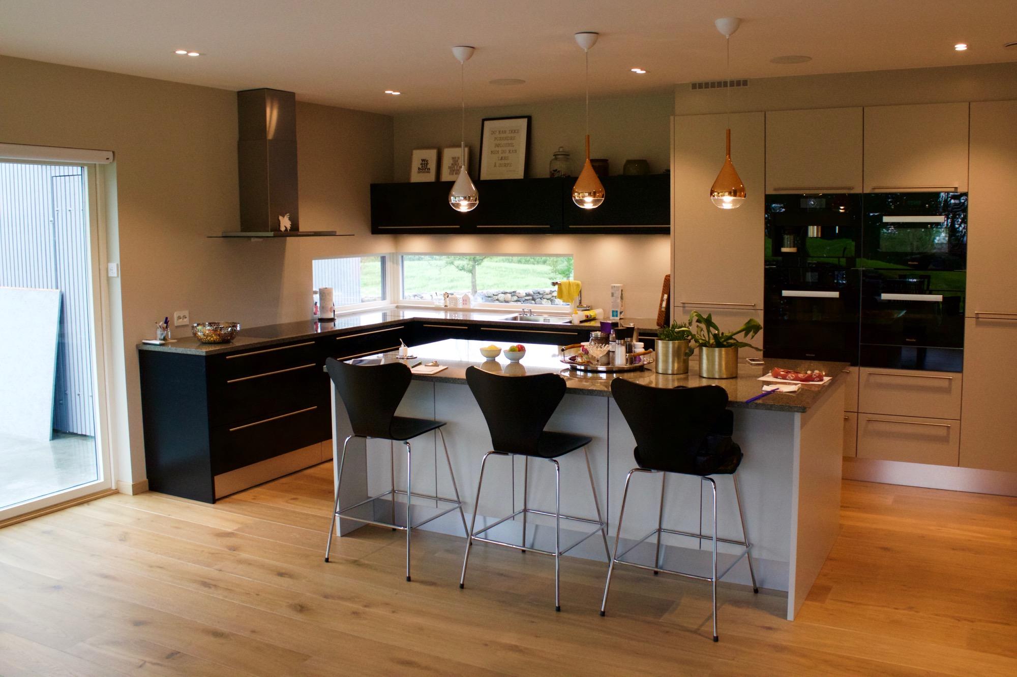 Fra kjøkken og spisestue kan man gå rett ut på terrassen og hagestua i vest med havutsikt