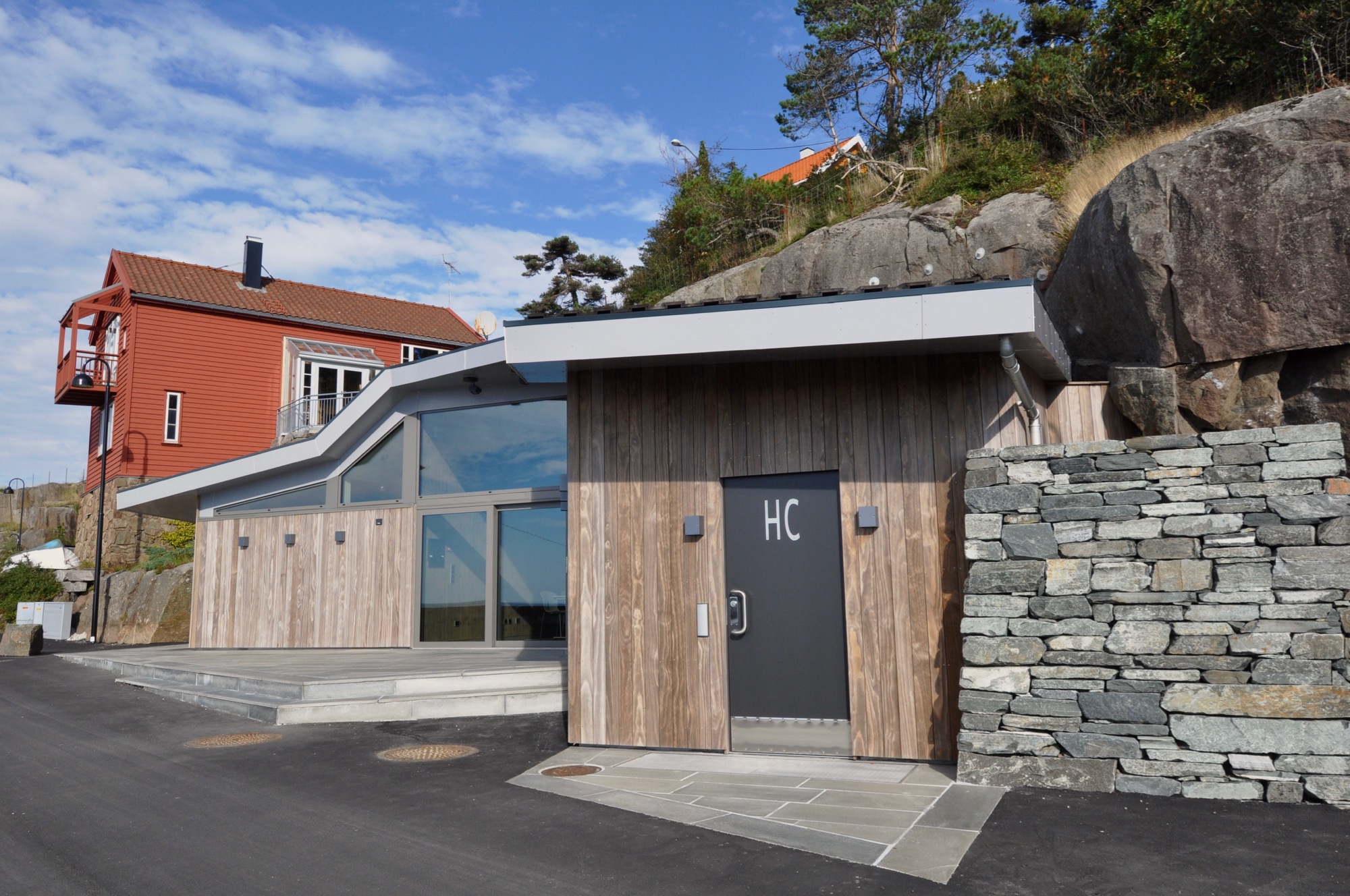 Bygningen fyller et skår i lanskapet og taket følger bergknausens form